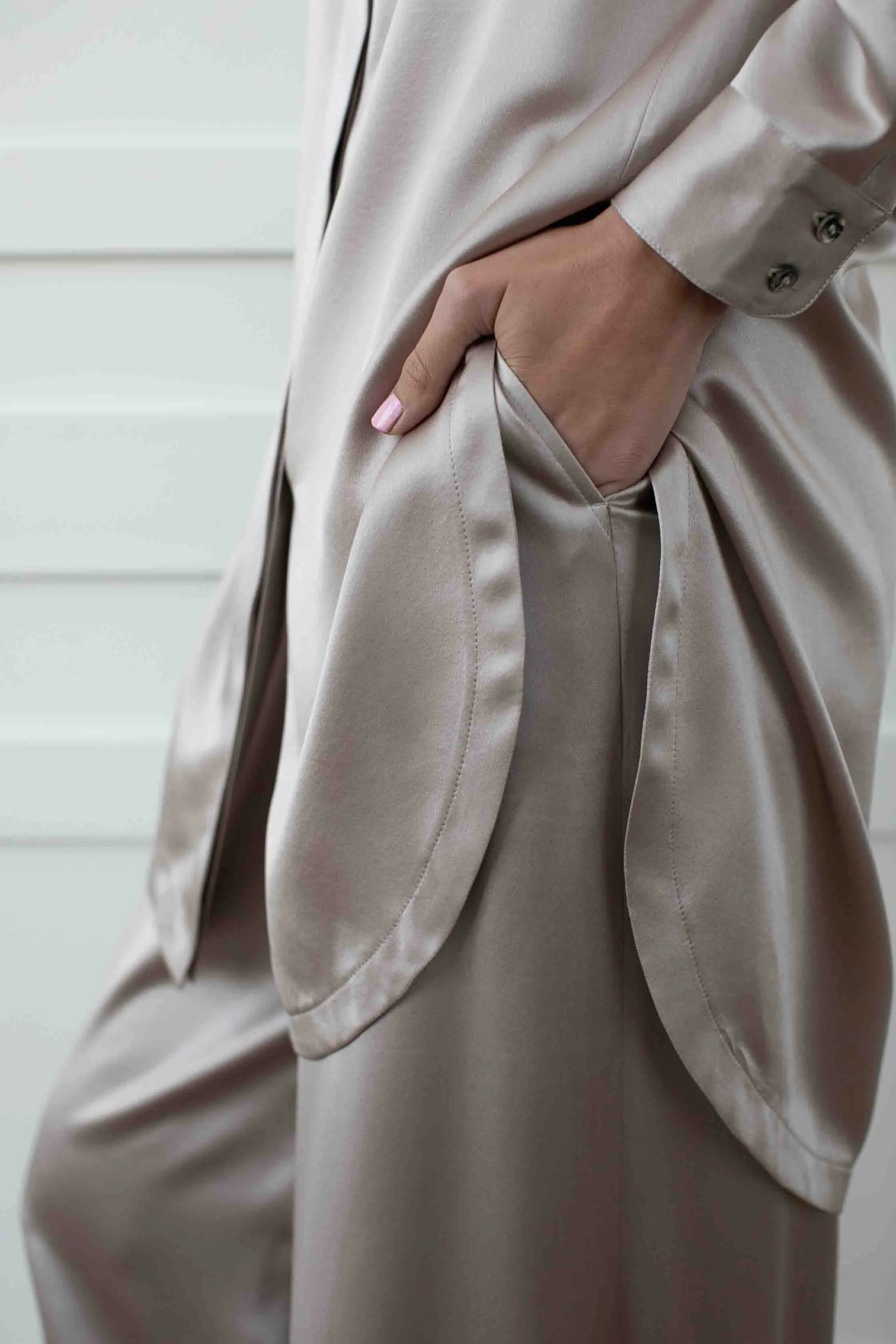Close view of a mink silk lounge shirt pocket and fabric drape.