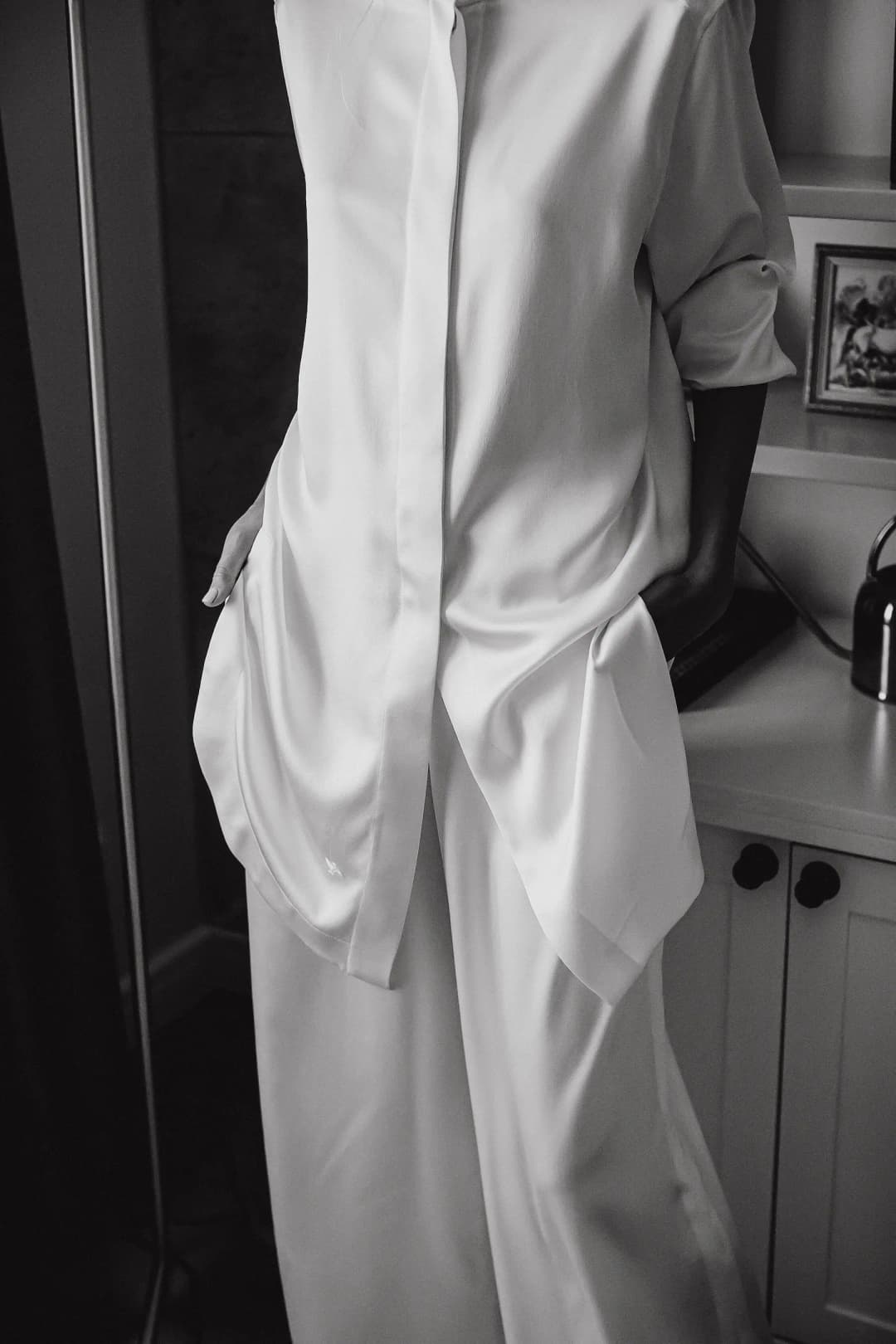 A silk lounge set worn in a home kitchen, shot in black and white.